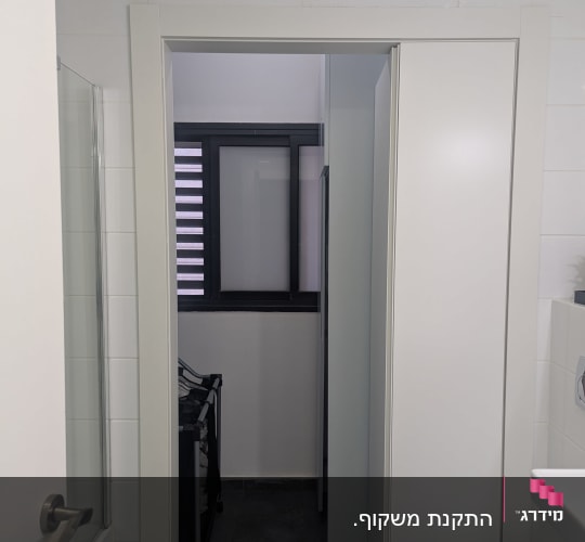 דלת לבנה בחדר אמבטיה עם חלון קטן